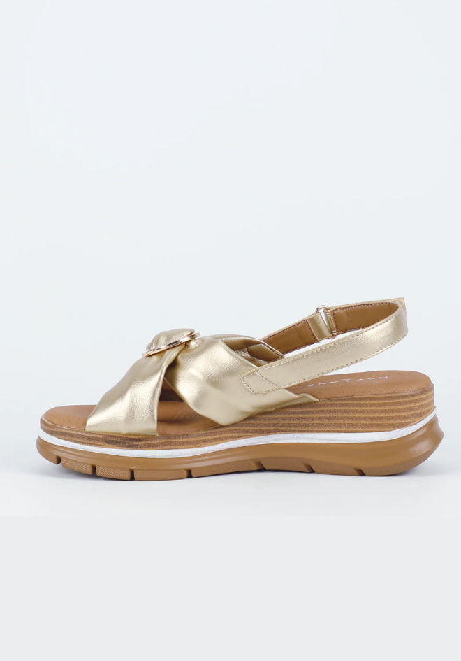 Gold sandal with a bow on a white background