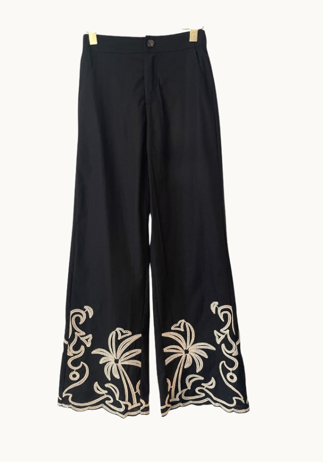 Black pants with palm tree embroidery on a white background