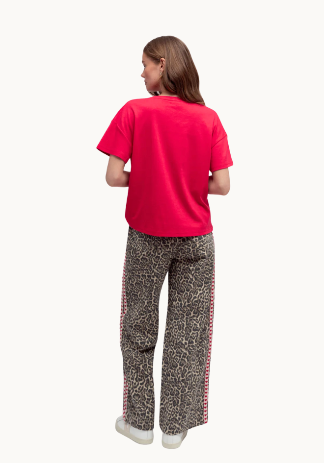 Person wearing a red shirt and patterned pants on a white background