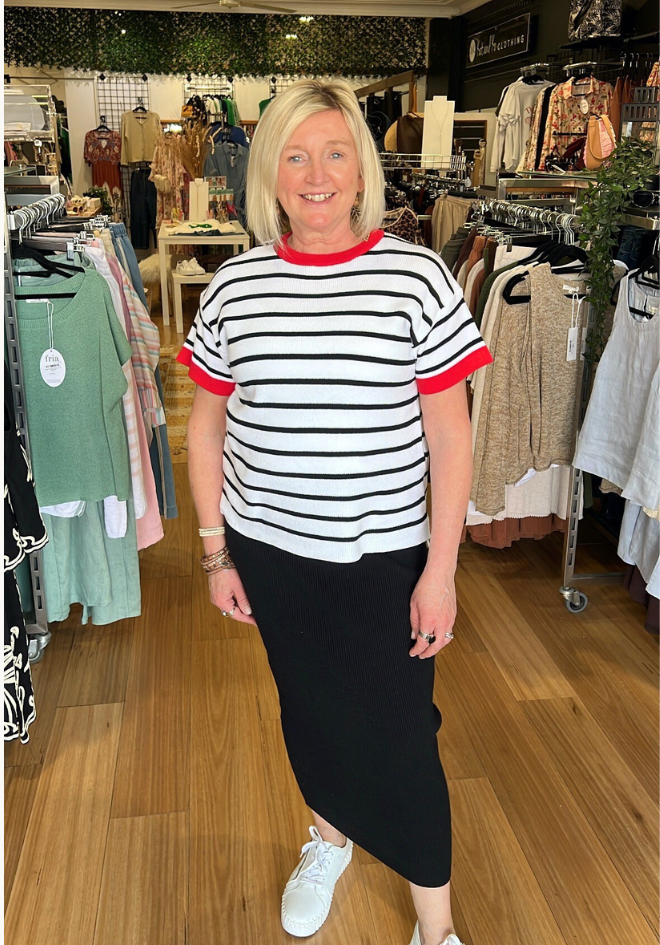 Woman wearing a striped shirt and black skirt in a clothing store