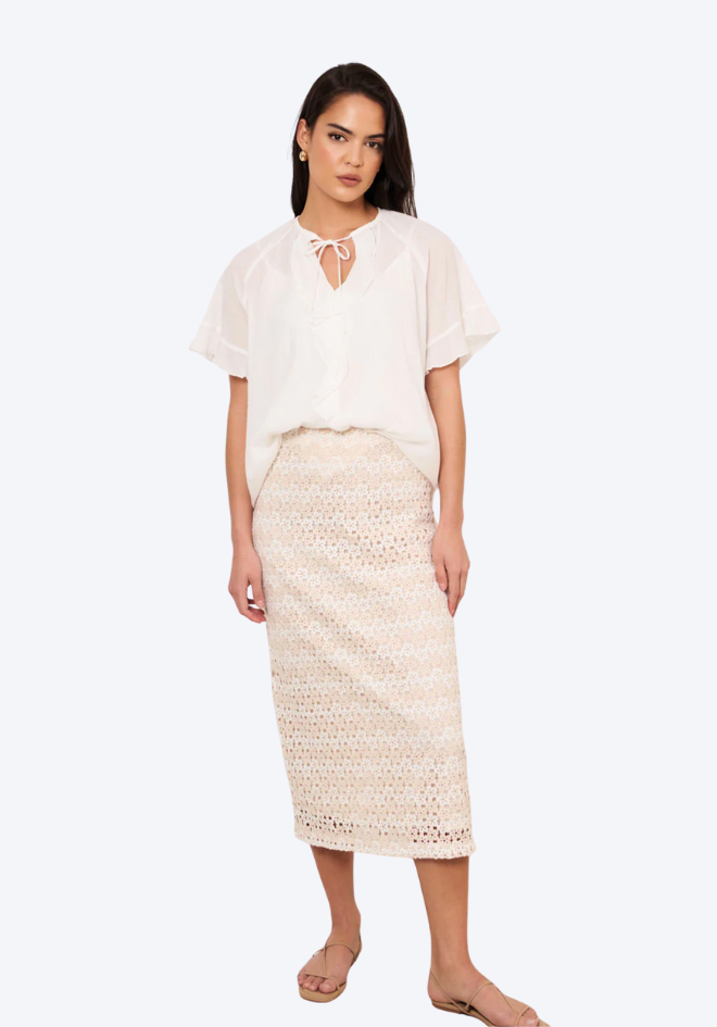 Woman wearing a white blouse and beige skirt on a white background