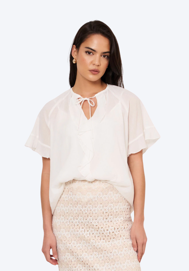Woman wearing a white blouse and beige skirt on a white background