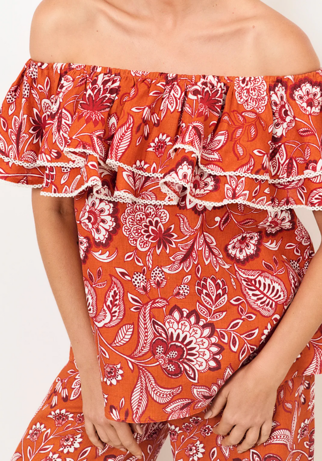 Red floral off-shoulder top with white accents on a plain background