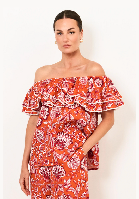 Woman wearing a red floral off-shoulder dress on a white background