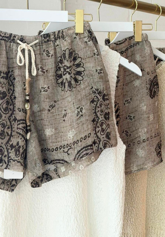 Patterned shorts hanging on a rack with a neutral background