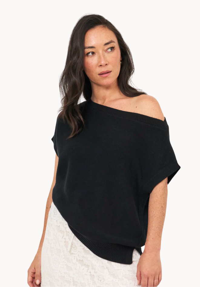 Woman wearing a black off-shoulder top with a white background