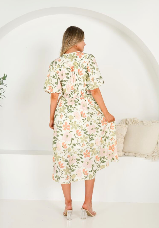 Woman wearing a floral dress in a minimal indoor setting