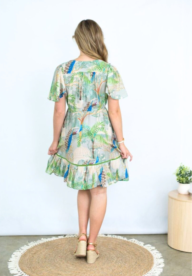 Woman wearing a tropical print dress with a white background