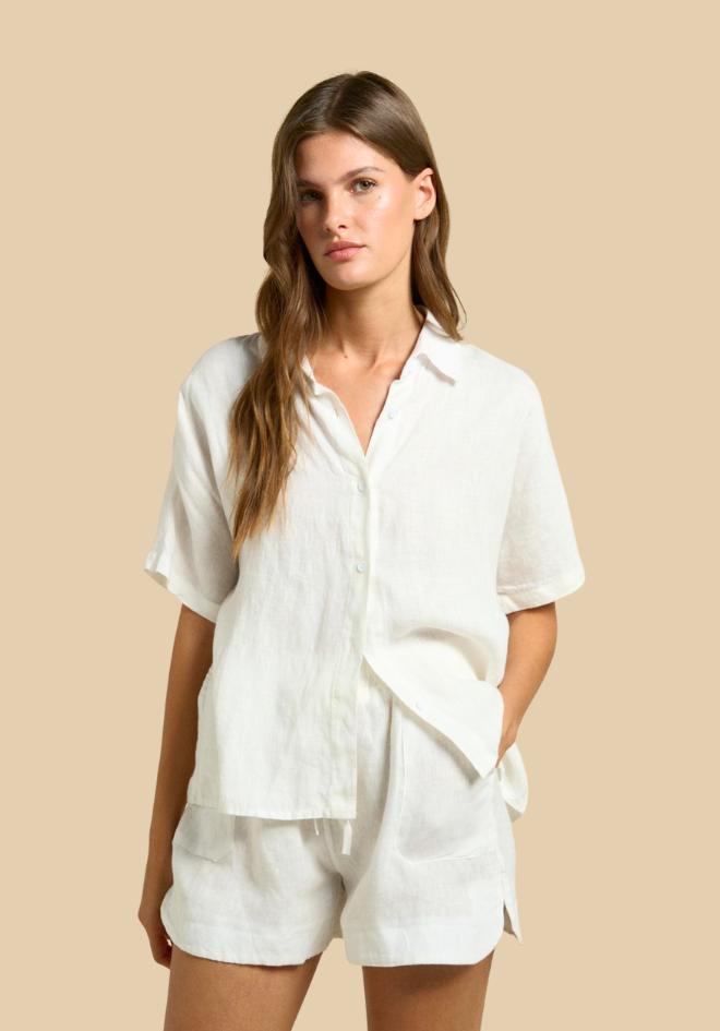 Woman wearing a white linen outfit on a beige background