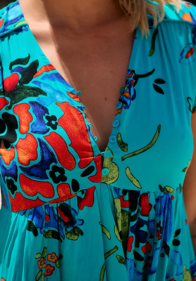 Close-up of a colorful dress with floral patterns on a blue background