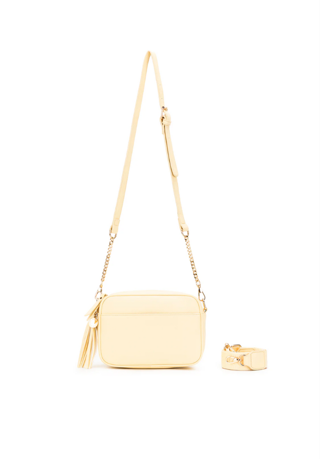 Cream-colored handbag with a matching ring on a white background