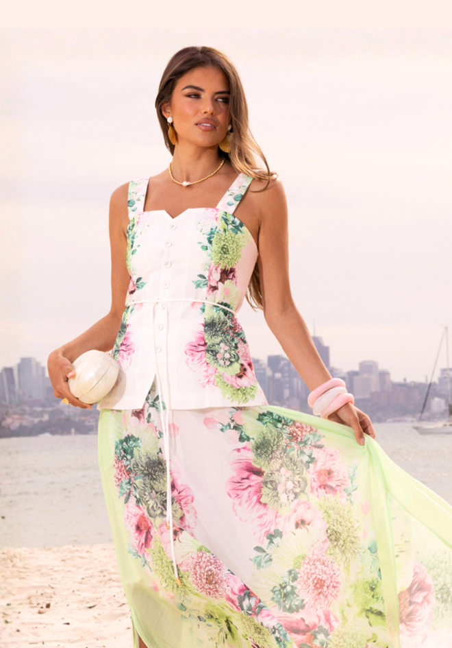 Sorbet Symphony Vest by Mia Milani — front view of white floral-print vest with button front, styled with a flowing pastel floral bottom outdoors, shop in Australia at Kat and Ko Clothing