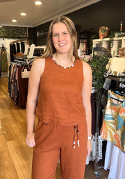 Gigi Top Rust — in-store front view of rust linen sleeveless tank top with beaded neckline, styled as a matching set with rust Gigi Pants and beaded necklace, available in Australia at Kat and Ko Clothing