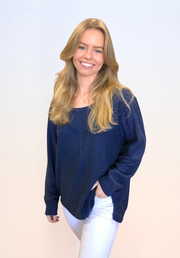 Sacha Top in Navy by Little Lies — front view of navy oversized long sleeve knit top with scoop neckline and relaxed fit, styled with white jeans and gold necklace, available in Australia at Kat and Ko Clothing