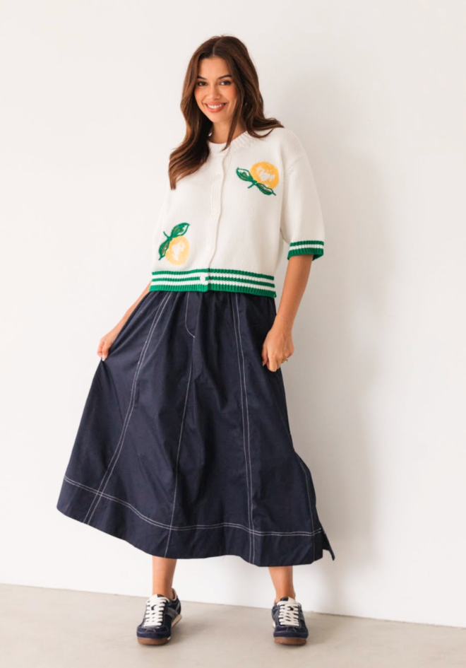 Label of Love Bella Midi Skirt Navy — front view styled outfit showing navy contrast stitch midi skirt with side pockets and split