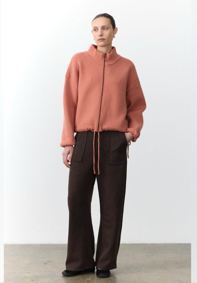 Little Lies Lenni Barrel Leg Pants Chocolate — full length front view of dark chocolate barrel leg pants with drawstring waist, styled with terracotta zip-up knit jacket and black flats, available in Australia at Kat and Ko Clothing