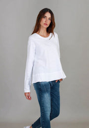 Sonya L/S Tee in White by 3rd Story The Label — angled front view of relaxed white long sleeve scoop neck tee styled with blue skinny jeans and white sneakers, available in Australia at Kat and Ko Clothing