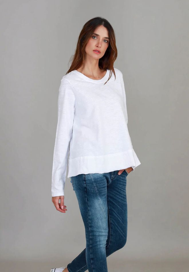 Sonya L/S Tee in White by 3rd Story The Label — angled front view of relaxed white long sleeve scoop neck tee styled with blue skinny jeans and white sneakers, available in Australia at Kat and Ko Clothing