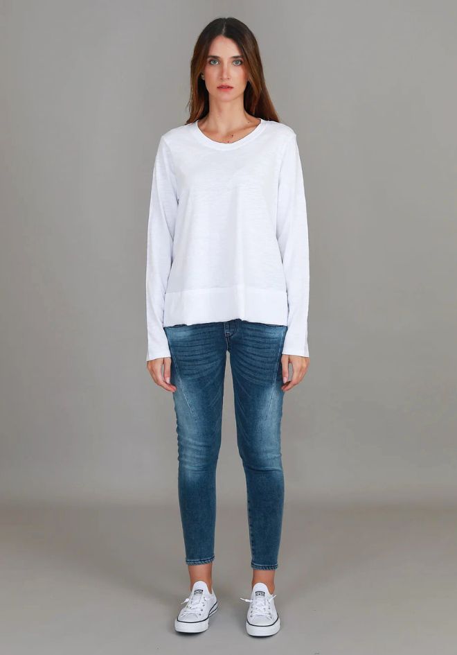 Sonya L/S Tee White 3rd Story The Label — full-length front view of relaxed white long sleeve scoop neck tee with curved hem, styled with blue skinny jeans and white sneakers, available in Australia at Kat and Ko Clothing