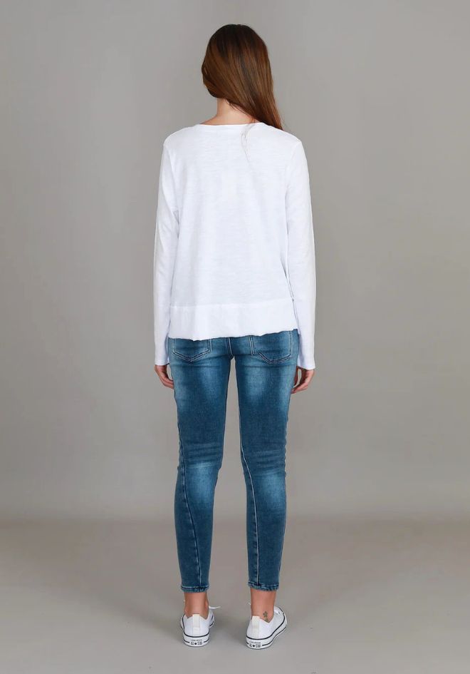 3rd Story The Label Sonya L/S Tee White — back view of relaxed white long sleeve tee with curved hem and side splits, styled with blue skinny jeans and white sneakers, available in Australia at Kat and Ko Clothing