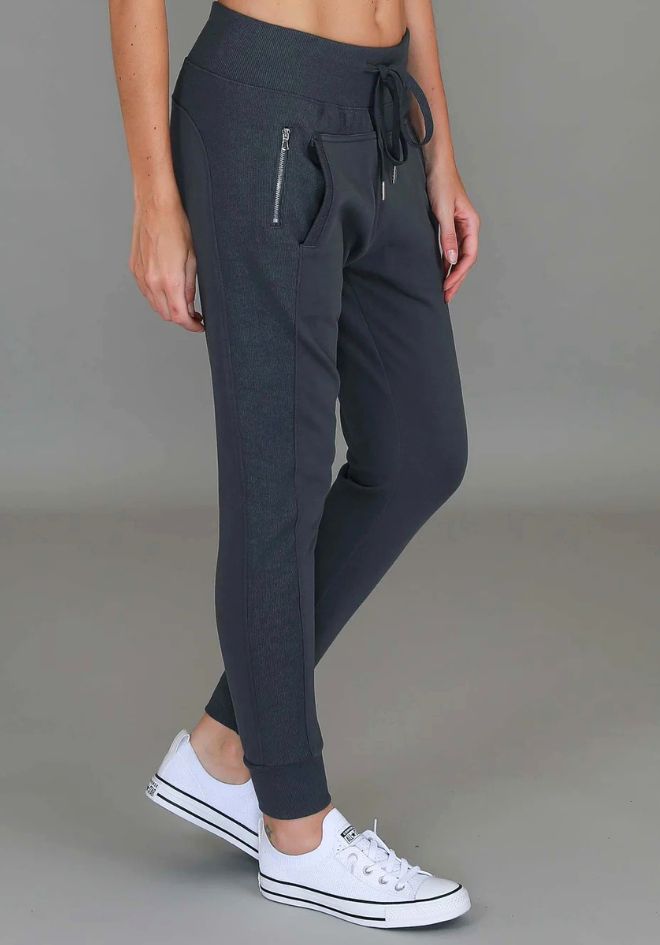 Byron Jogger Charcoal 3rd Story The Label — side view of charcoal slim-fit jogger pants with drawstring waist and zip pocket detail, styled with white Converse sneakers, available in Australia at Kat and Ko Clothing