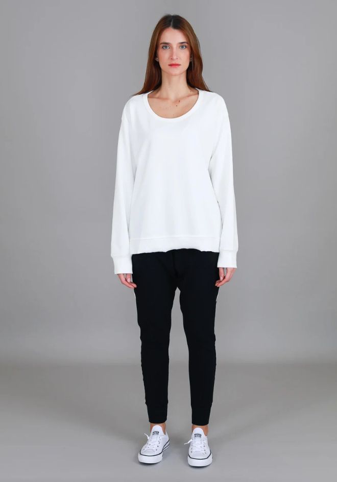 Ulverstone Sweater White 3rd Story The Label — full-length front view of relaxed white scoop neck sweater with dropped shoulders and curved hem, styled with black jogger pants and white Converse sneakers, available in Australia at Kat and Ko Clothing