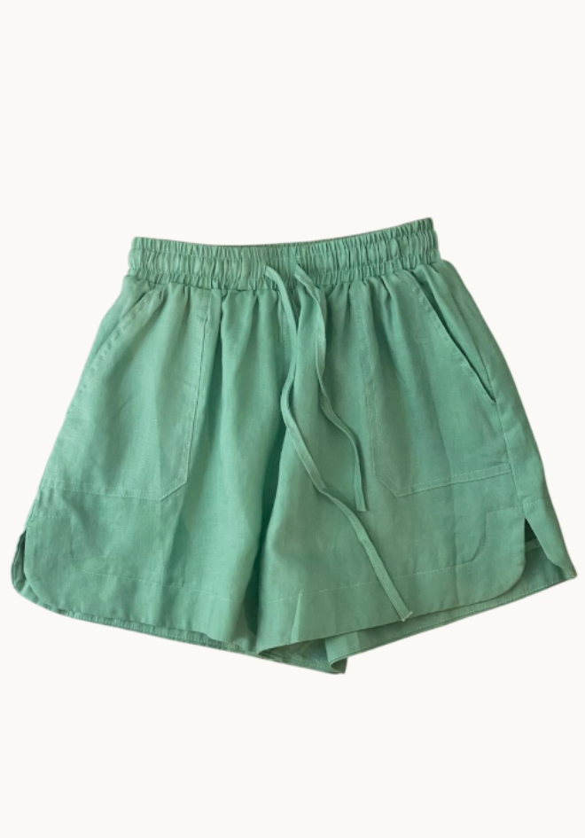 Aqua colored linen shorts with an elastic waistband and adjustable tie, featuring pockets.