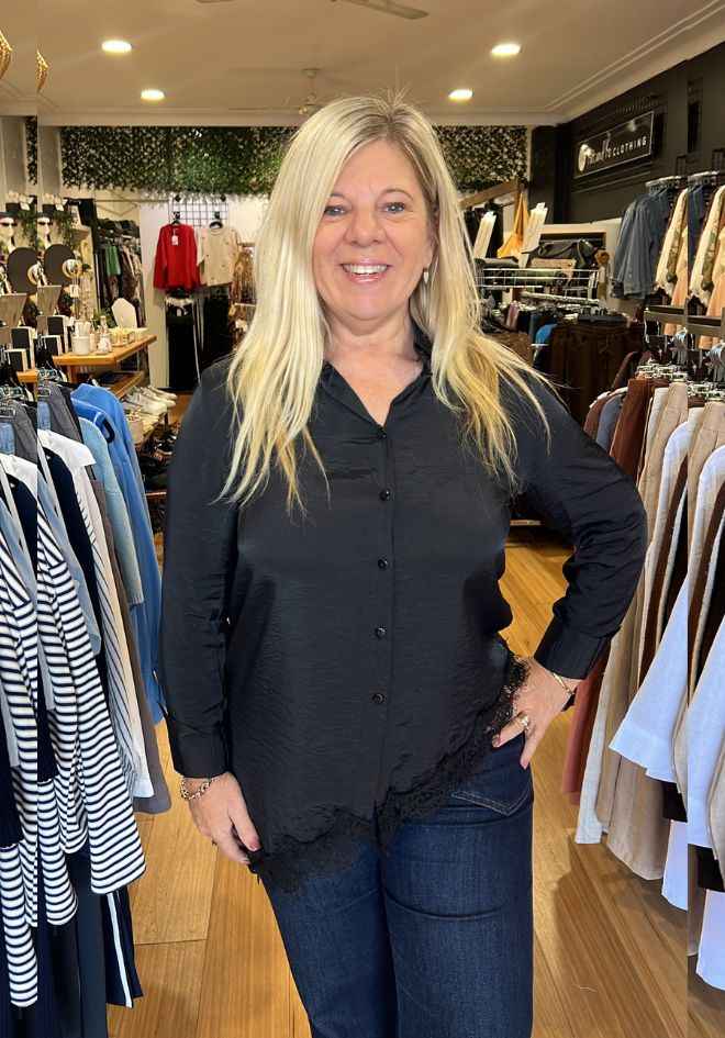 Ave The Label Satine Asymmetrical Lace Blouse — silky black top with lace hem detail, styled for a polished evening look