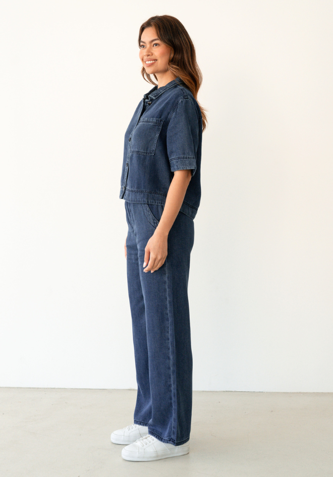 Collette Chambray Pant Label of Love — side view of dark blue wide-leg chambray pants styled as a co-ord set with matching cropped shirt and white sneakers, available in Australia at Kat and Ko Clothing