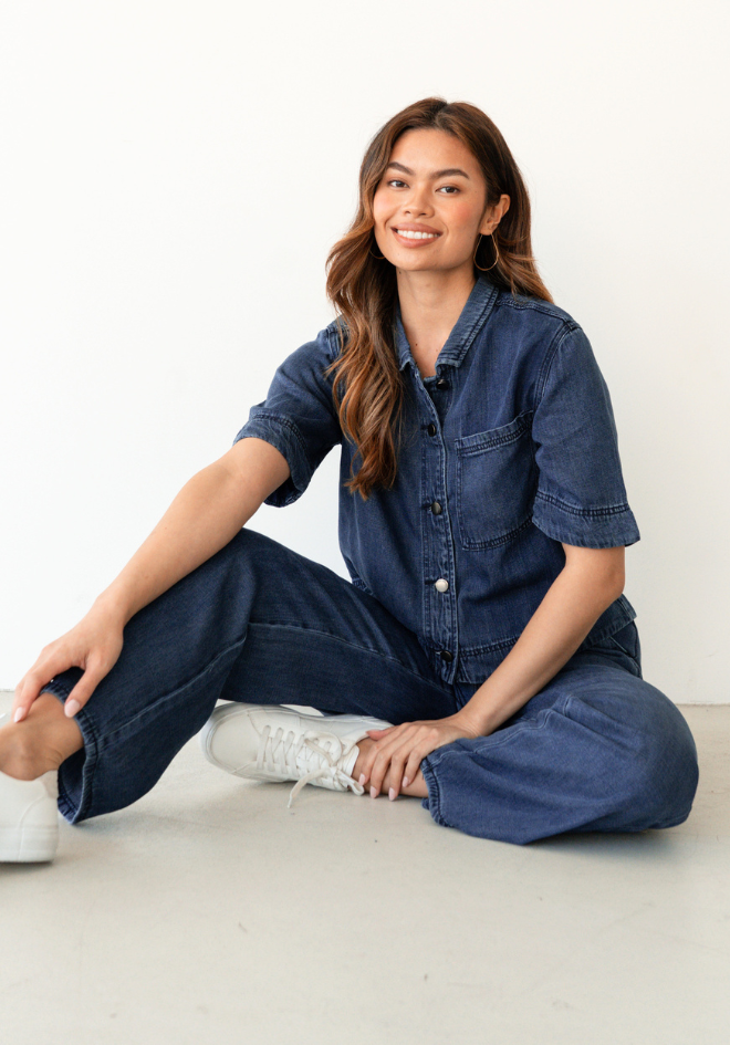 Label of Love Collette Chambray Shirt — seated lifestyle shot of dark blue chambray cropped shirt with short sleeves and button-through front, styled with wide-leg denim and white sneakers, shop in Australia at Kat and Ko Clothing