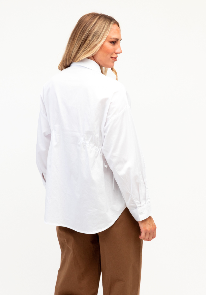 Label of Love Kori Shirt White — back view of white 100% cotton collared shirt with long sleeves and curved hem, styled with tan wide-leg trousers, shop in Australia at Kat and Ko Clothing