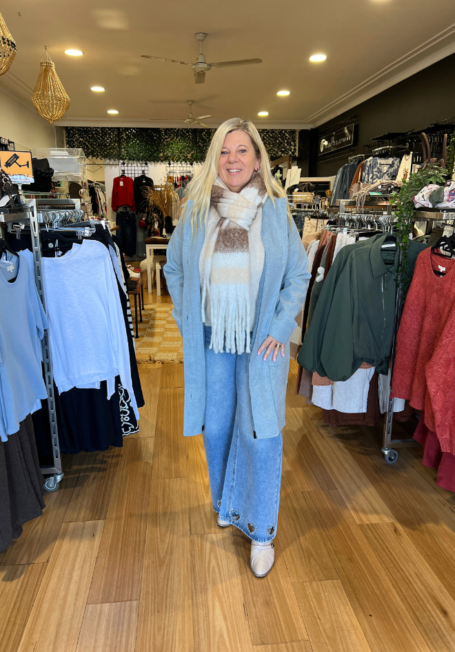 Refuge Lexie Coat in Baby Blue — in-store lifestyle shot of longline baby blue coat styled with wide-leg denim and a cream fringe scarf, shop in Australia at Kat and Ko Clothing