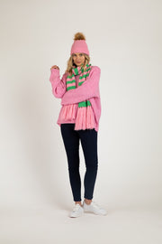 Lunar Scarf Floss Stripe by Betty Basics — pink and green striped knitted scarf with fringe tassels, styled with pink sweater and pom pom beanie, full length front view, shop in Australia at Kat and Ko Clothing