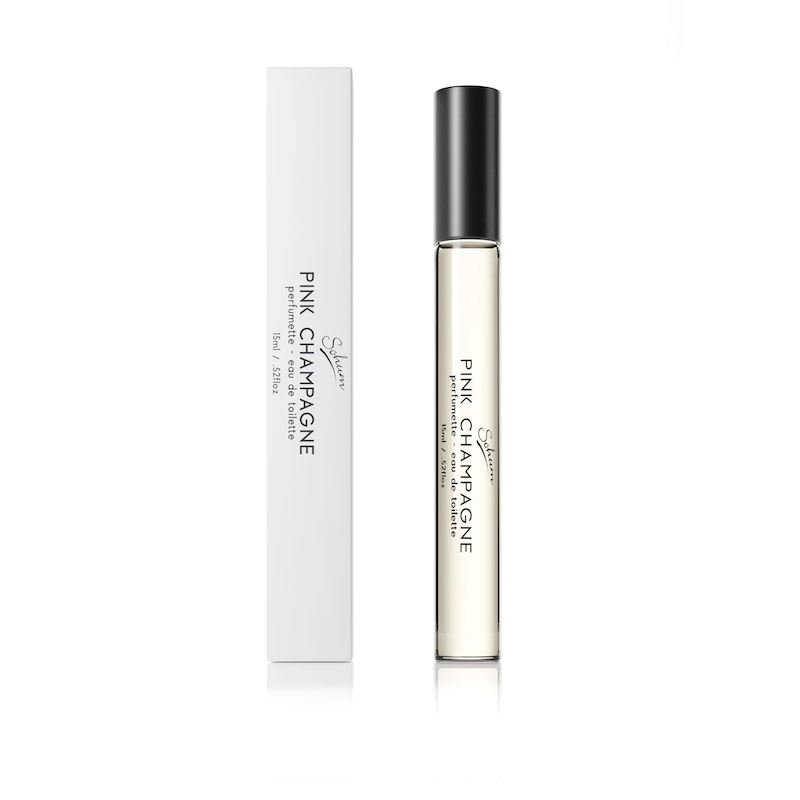 A white bottle with a black rollerball applicator, labeled 'Pink Champagne Signature Perfumette'.